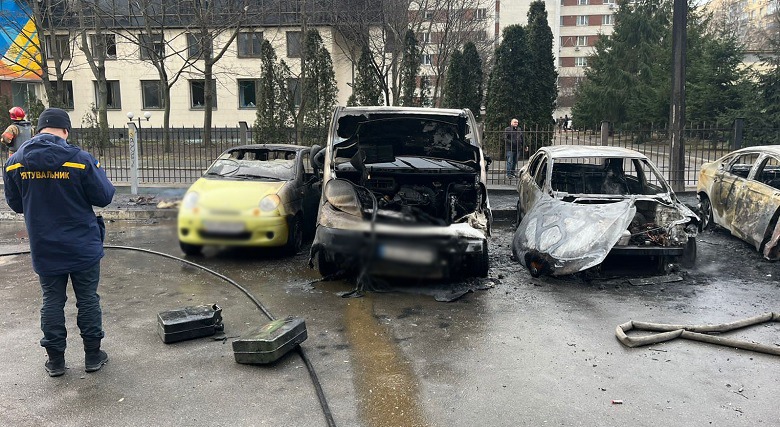 Ukrainian emergency rescuer beside burned civilian cars after a Russian missile strike in Kyiv on March 9, 2023