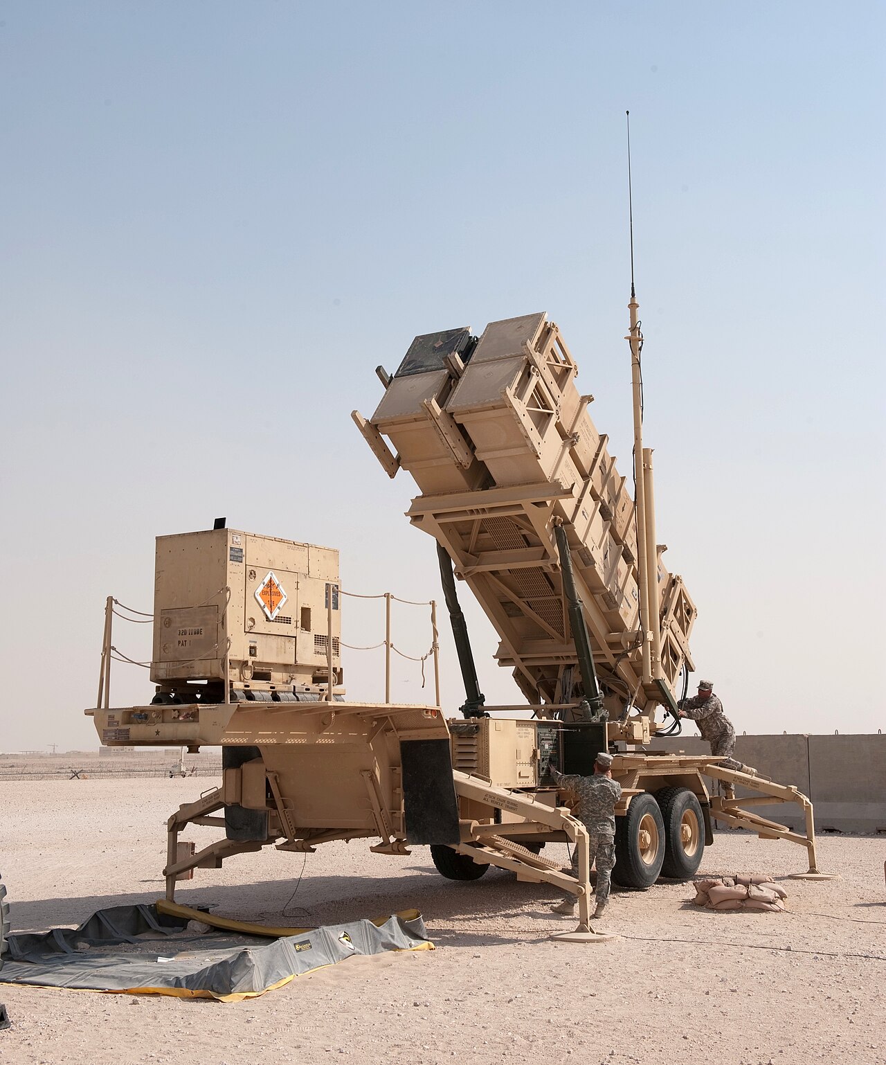 U.S. military MIM-104 Patriot surface-to-air missile launcher with service members in a desert deployment