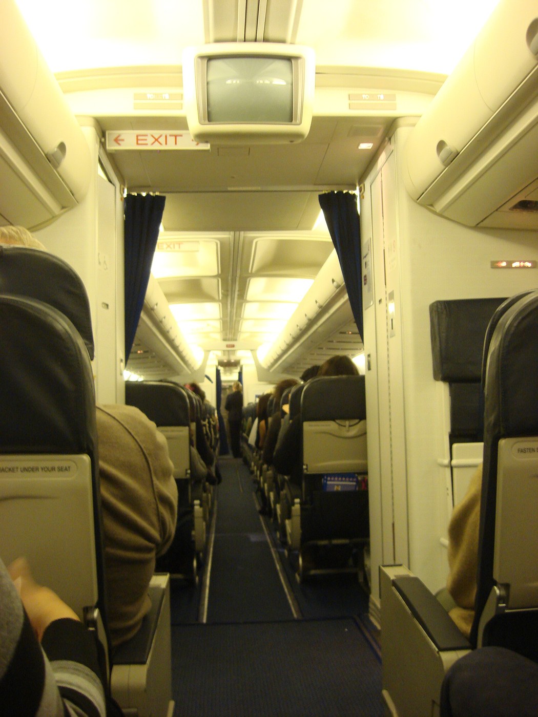 Airplane cabin aisle with passenger seats during boarding