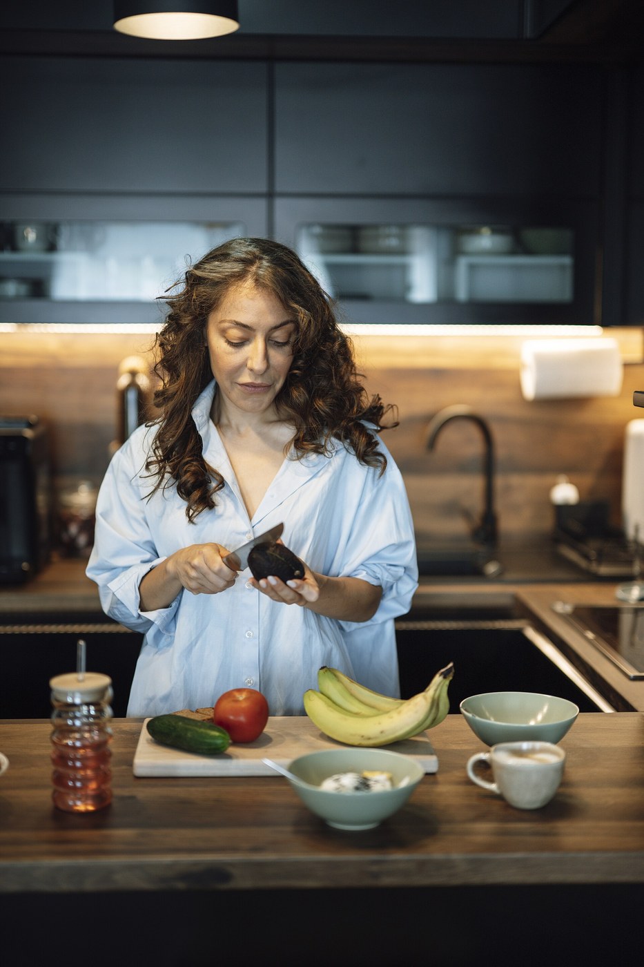 Person preparing food in a kitchen while cutting vegetables for food-safety hygiene context