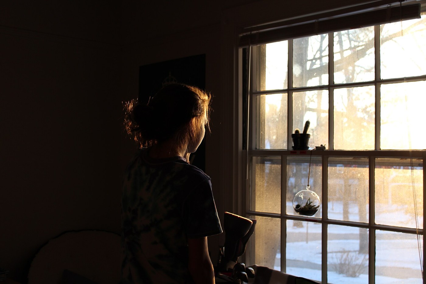 Person looking quietly out a window in a reflective moment