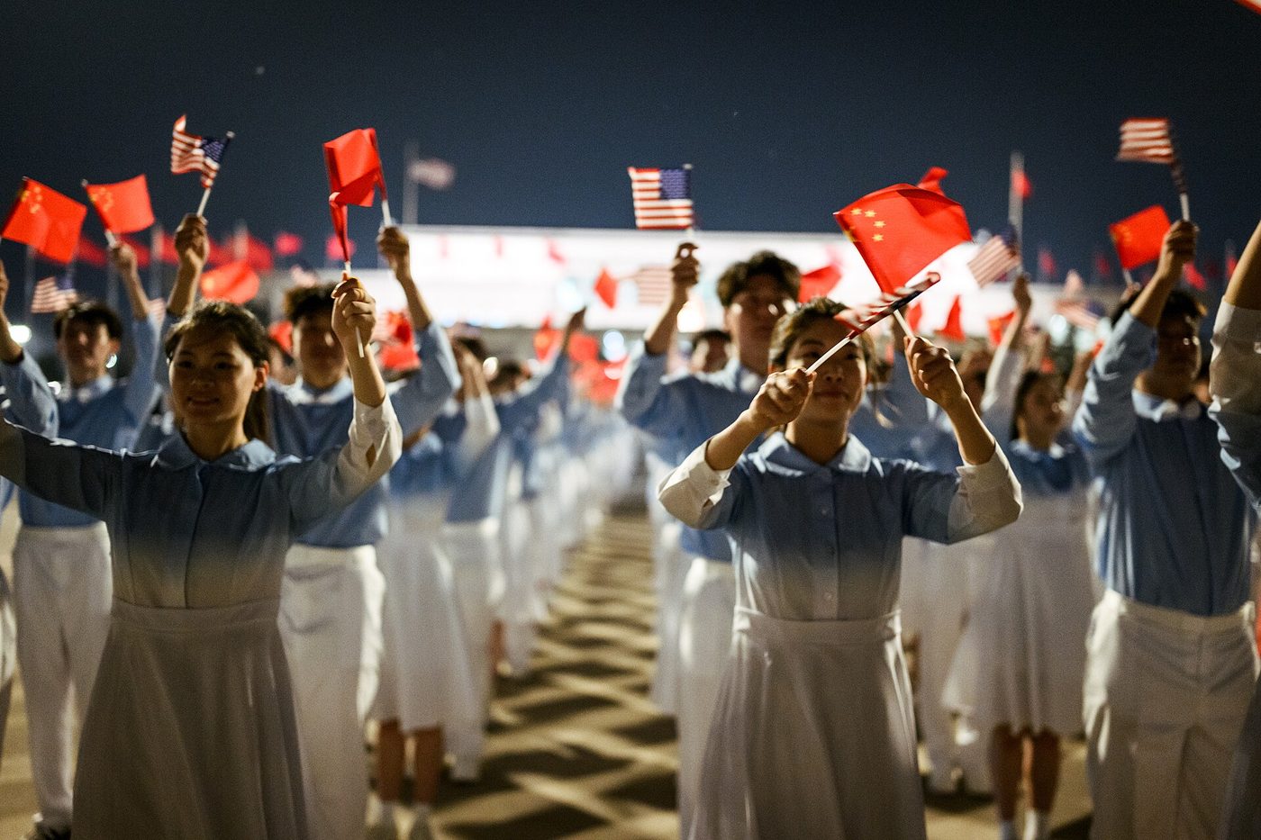 People holding United States flags and flags of the People’s Republic of China