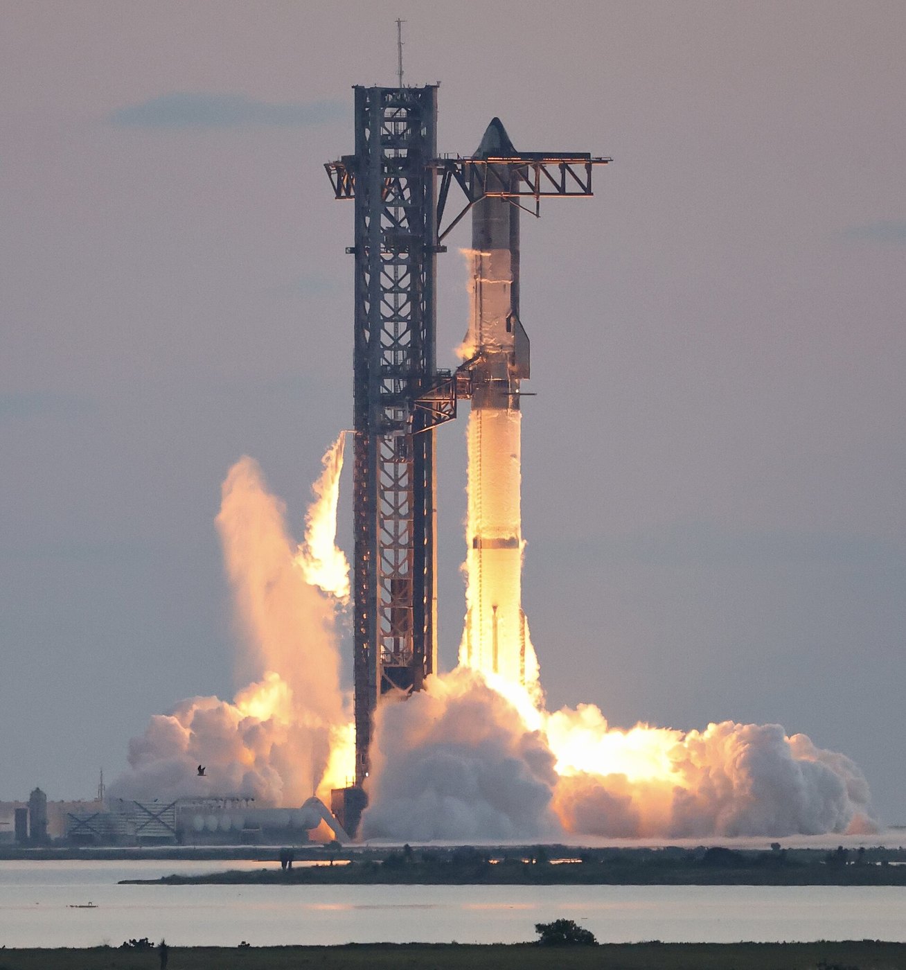 SpaceX Starship engines igniting on the launch mount during an integrated flight test