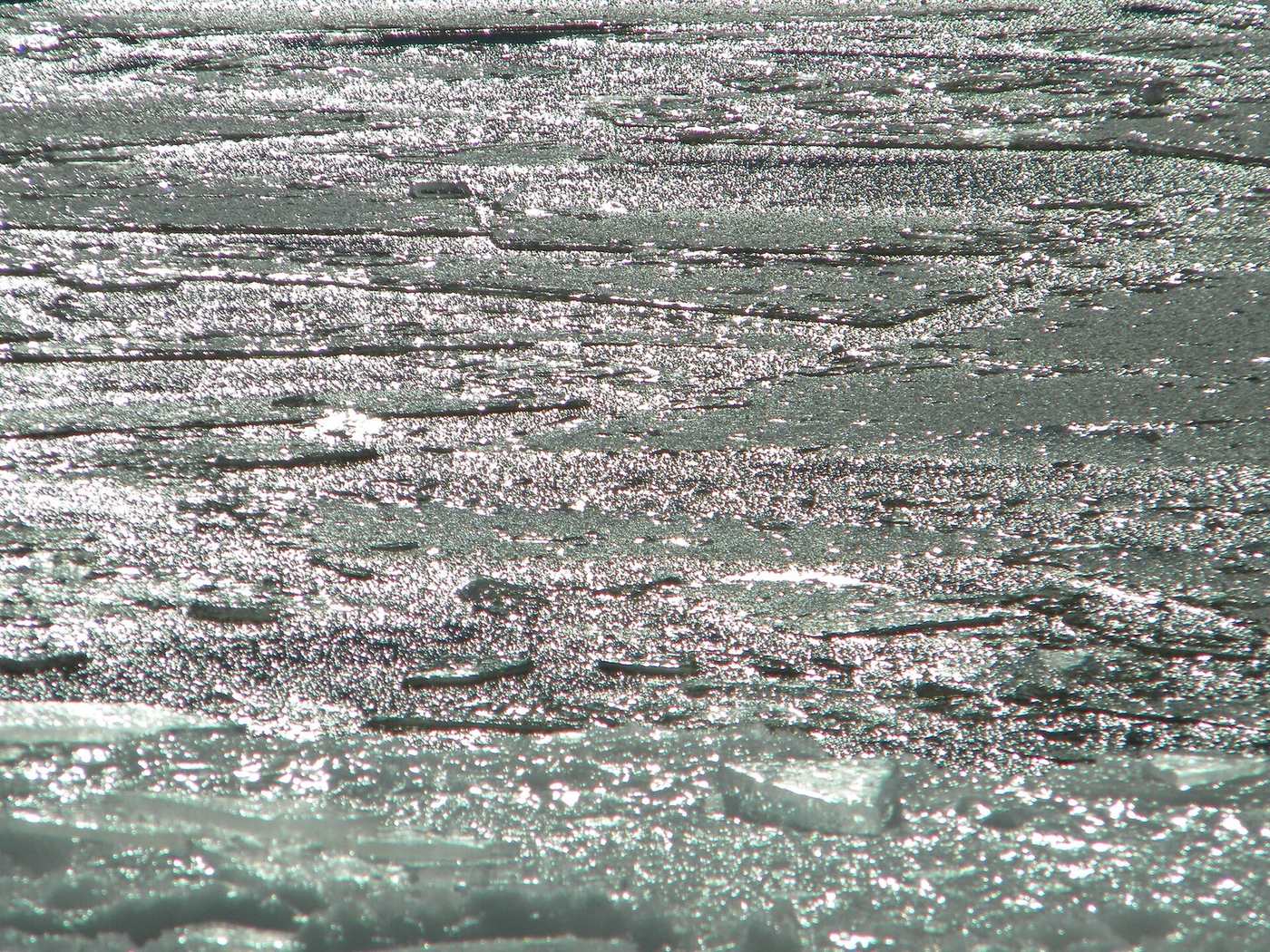 Broken Arctic sea ice and open dark water under autumn sky