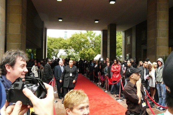 Red carpet photographers and celebrity backdrop at a weekend premiere