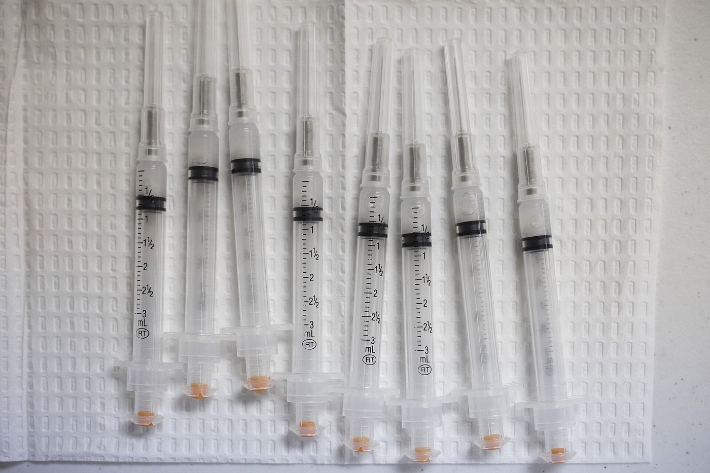 Row of syringes laid out on a white pad