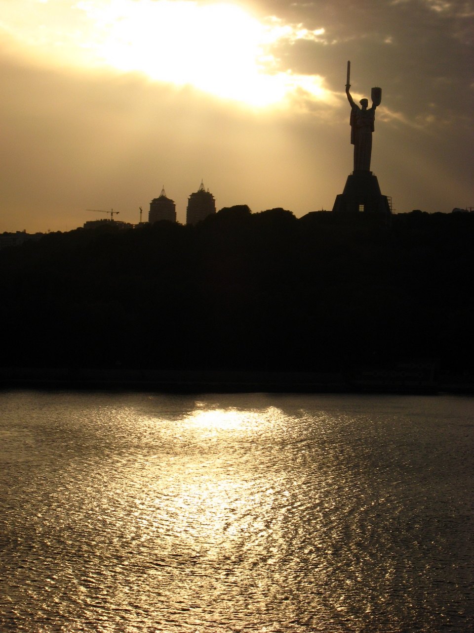 Kyiv skyline at sunset with the Motherland monument and the Dnipro River
