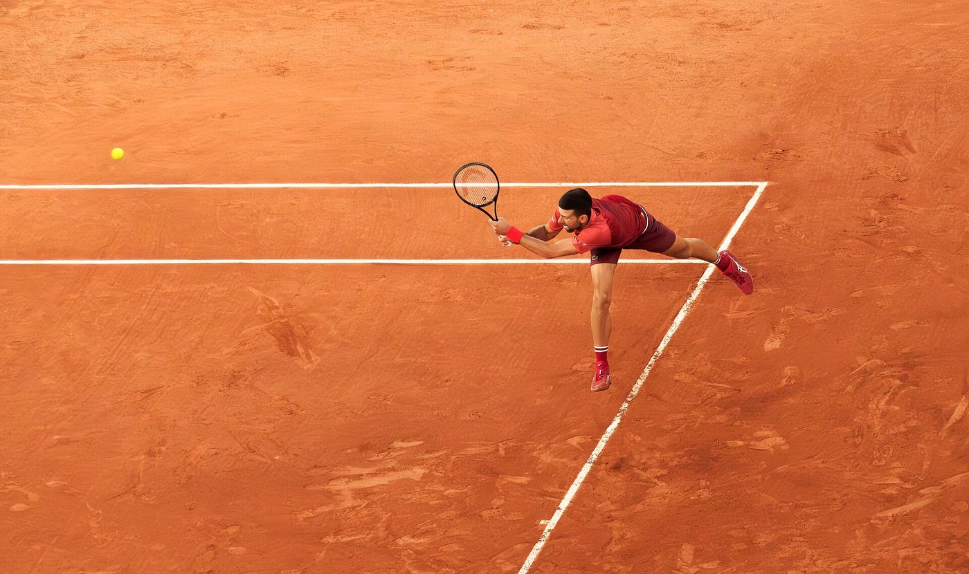 Novak Djokovic returning a serve with his backhand at the 2024 French Open