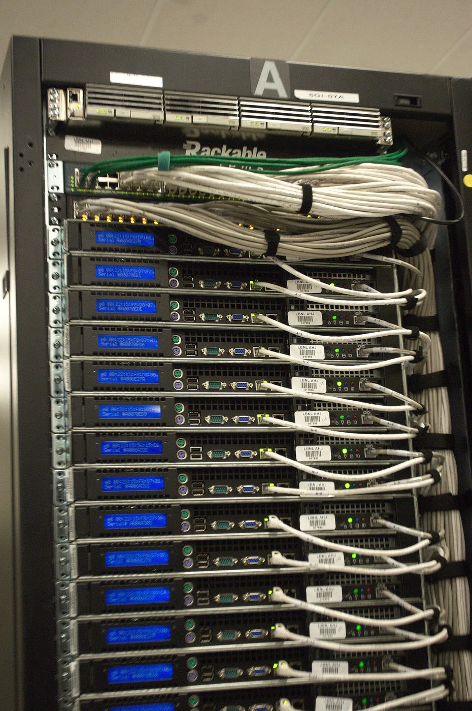 The back of a server rack at the NERSC supercomputing center, with blue LED screens
