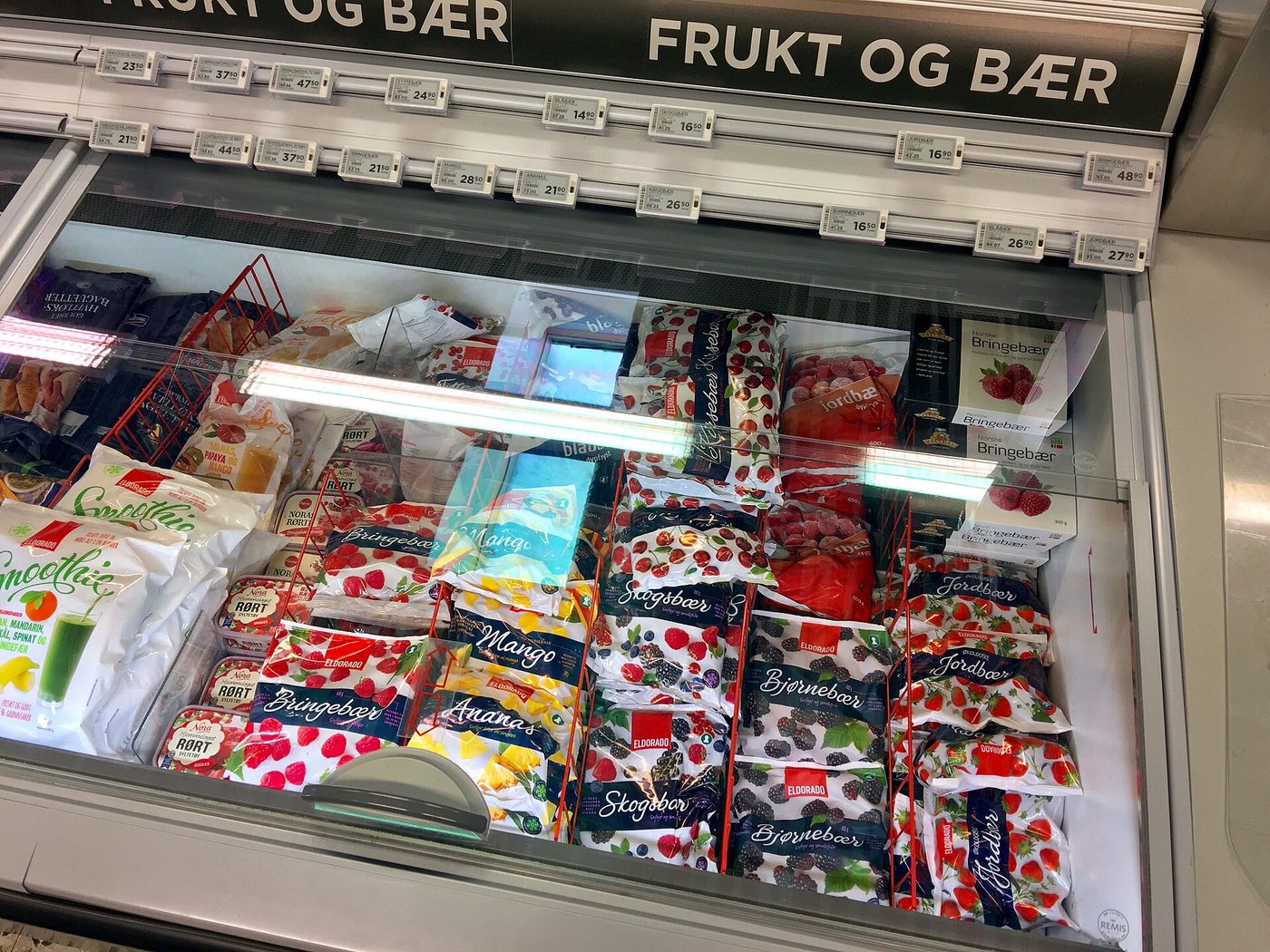 A supermarket chest freezer stocked with bags of frozen fruit and berries in Tønsberg, Norway