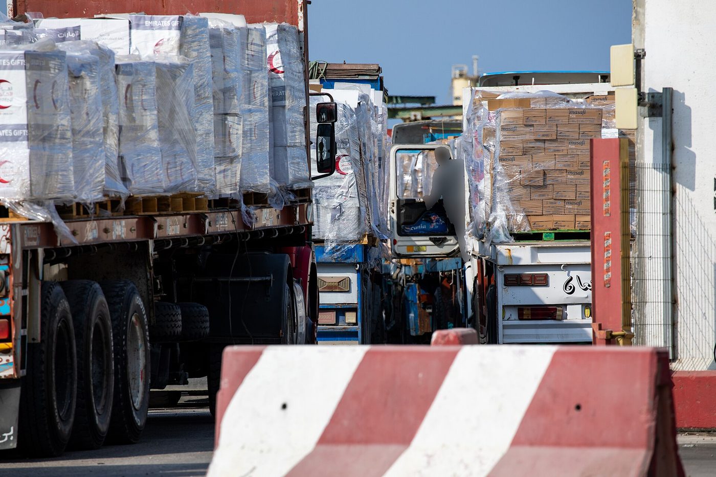 Drivers prepare to unload humanitarian aid trucks at the Kerem Shalom crossing into Gaza