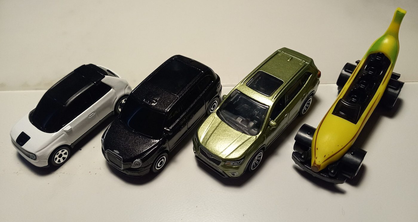 Four Matchbox toy vehicles from 2020 and 2021 lined up on a table