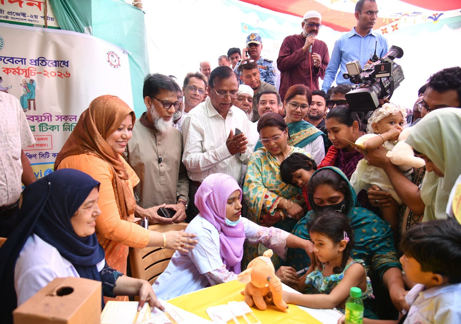 Health workers give children measles-rubella vaccines as officials look on at a special campaign site in Dhaka, April 2026