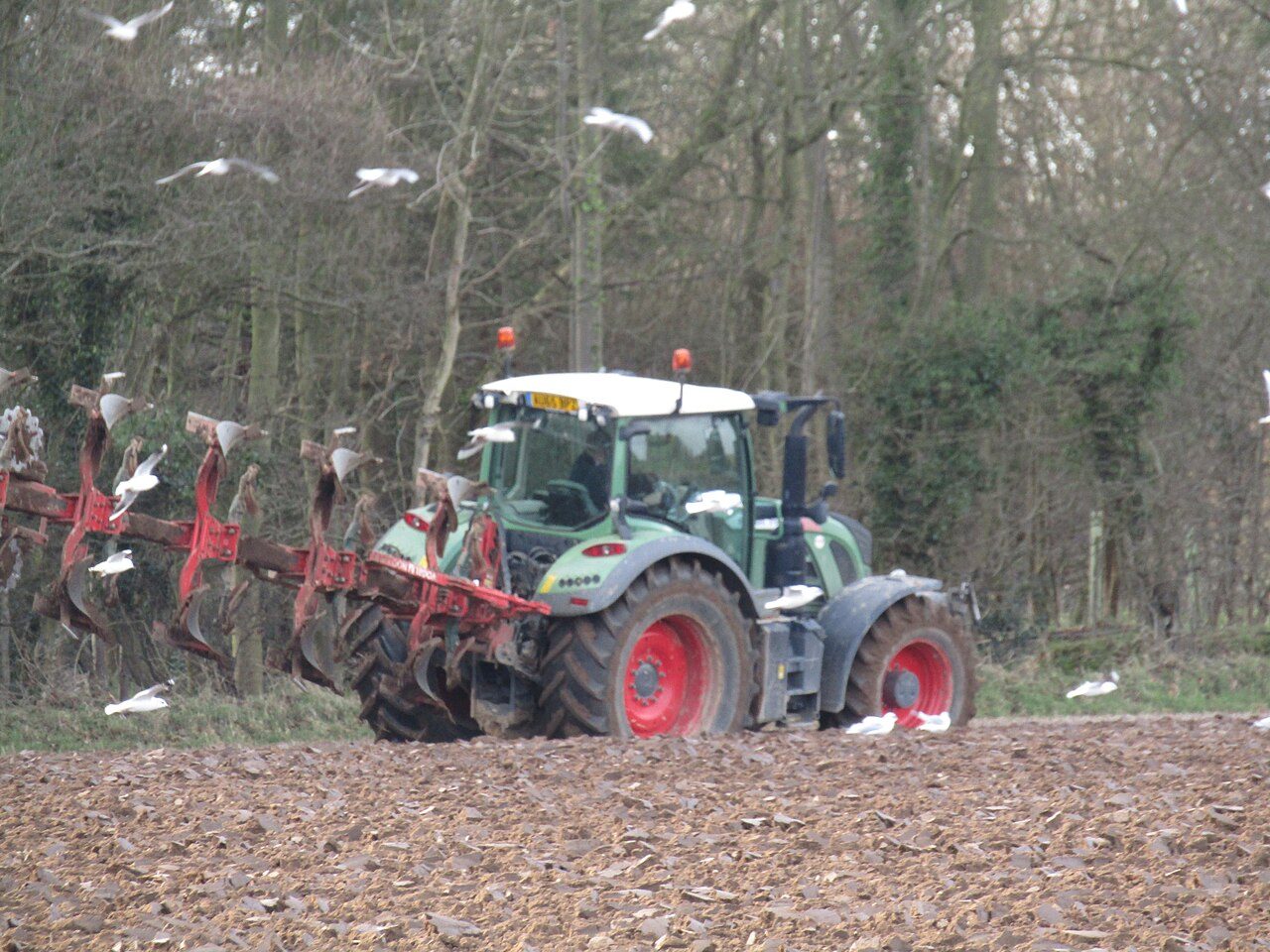 A tractor ploughing a field near Southrepps, Norfolk, in winter