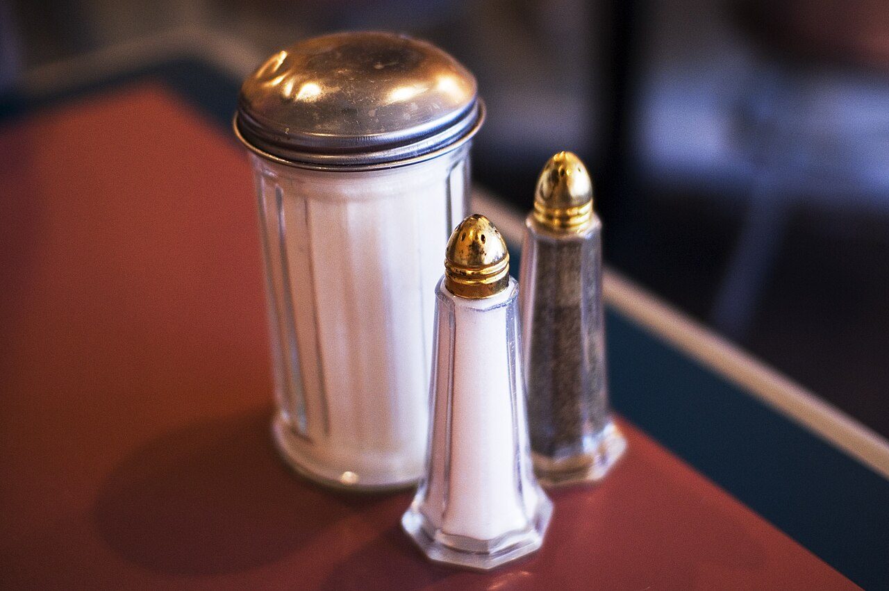 Glass salt, sugar and pepper shakers on a table