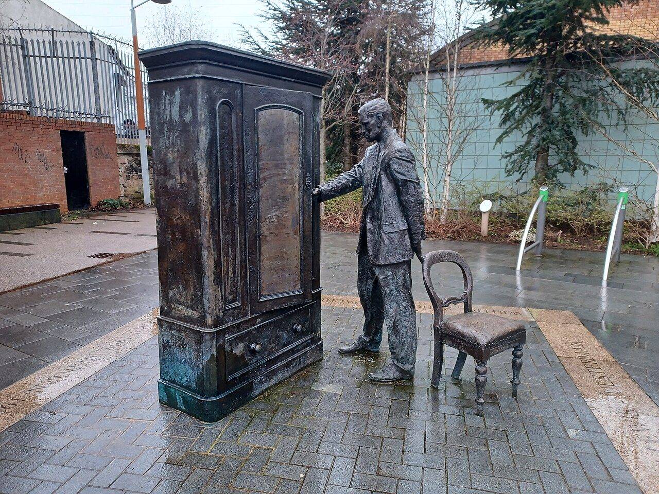 A bronze sculpture of C.S. Lewis at a wardrobe in C.S. Lewis Square, East Belfast