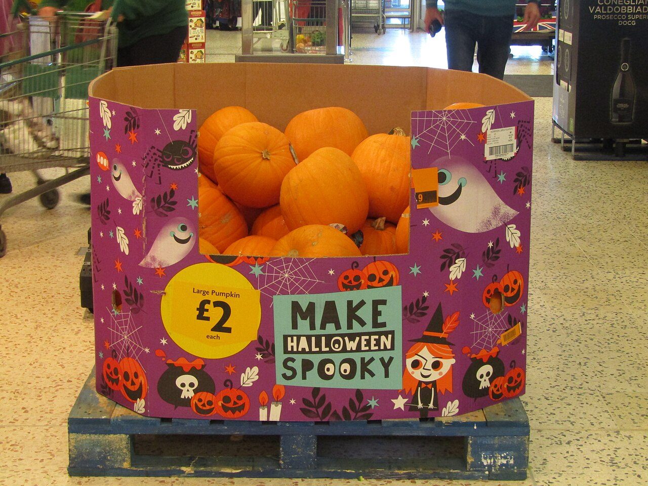 Pumpkins stacked for sale outside a supermarket