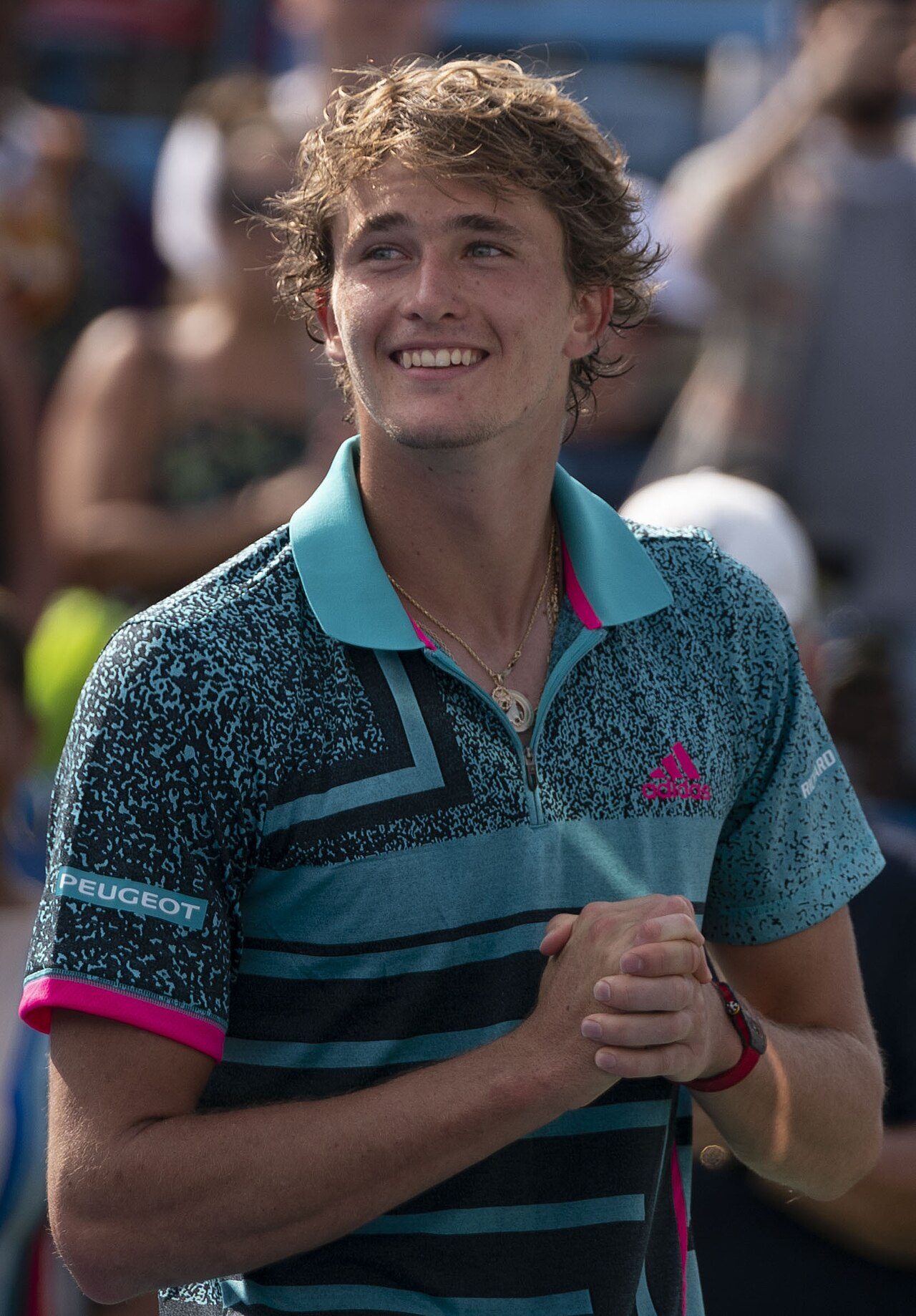 Alexander Zverev, smiling, in a teal shirt