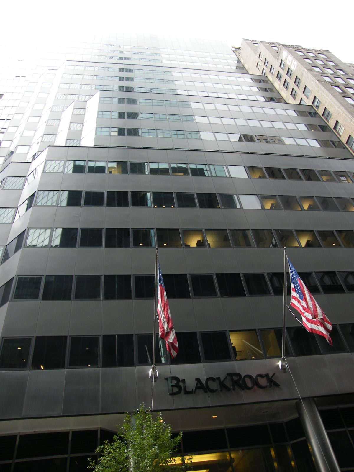 A BlackRock office building in New York with two American flags over the entrance