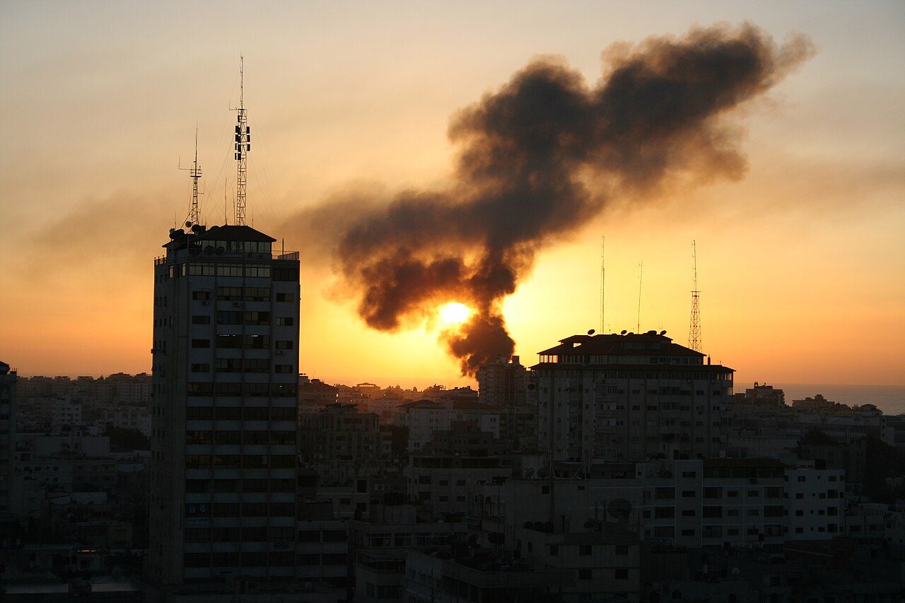 Smoke rising over the Gaza skyline at sunset