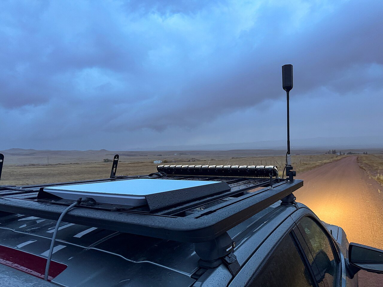 A flat Starlink satellite dish mounted on the roof of a truck