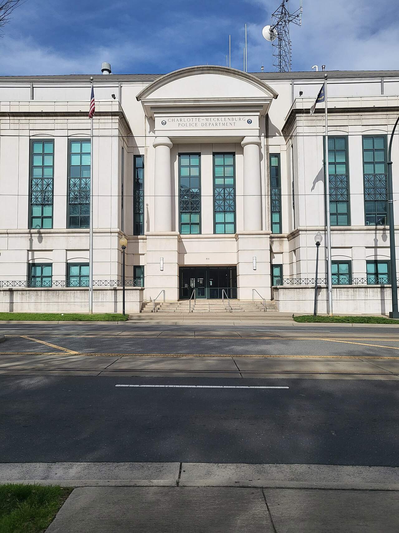 The glass entrance of a modern police headquarters building with a sign above the doors
