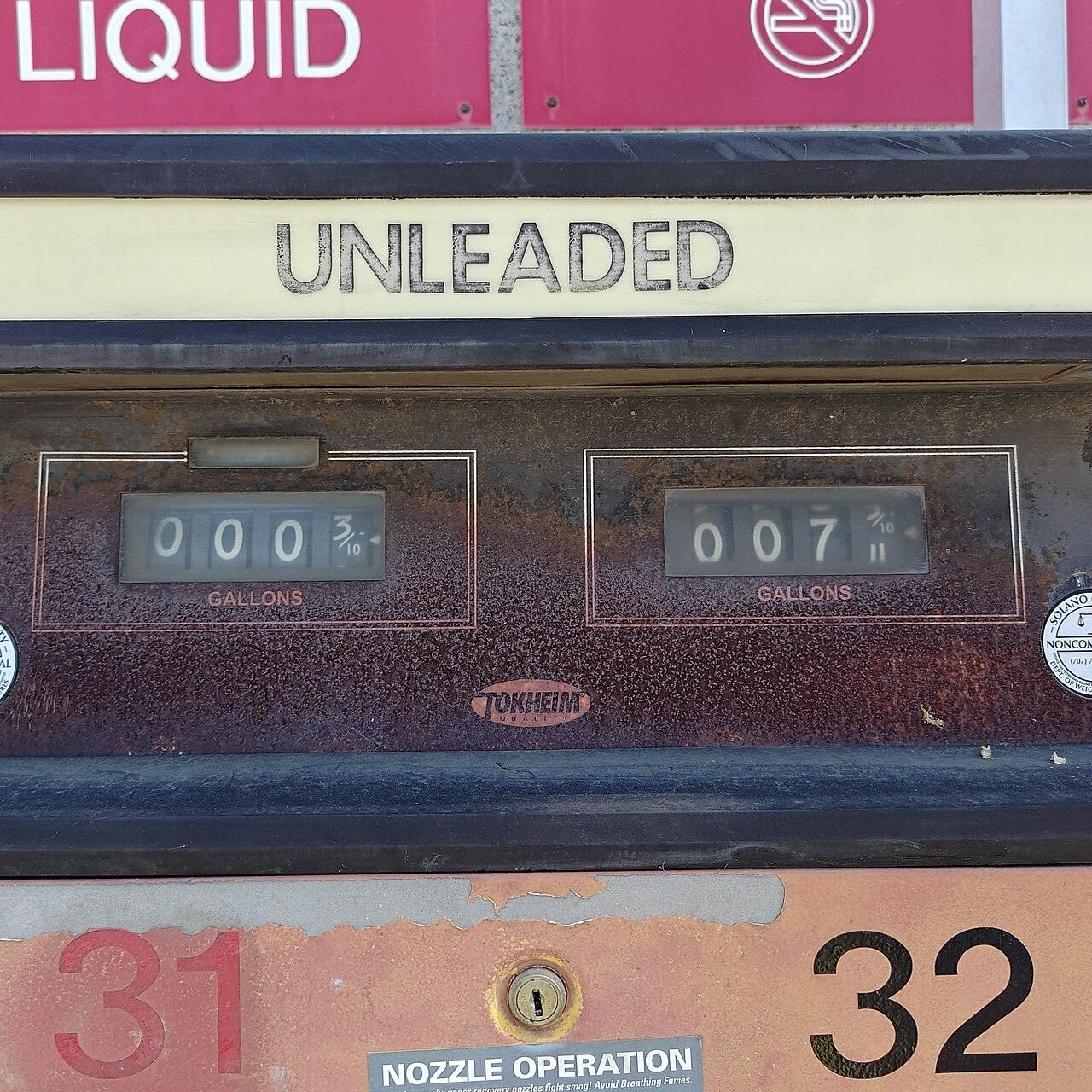 Close-up of a gasoline pump with an unleaded label and mechanical number counters