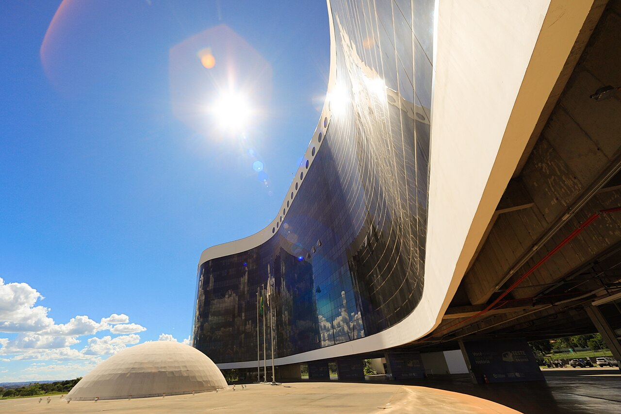 The curved glass and concrete headquarters of Brazil's Superior Electoral Court in Brasília under a bright sun
