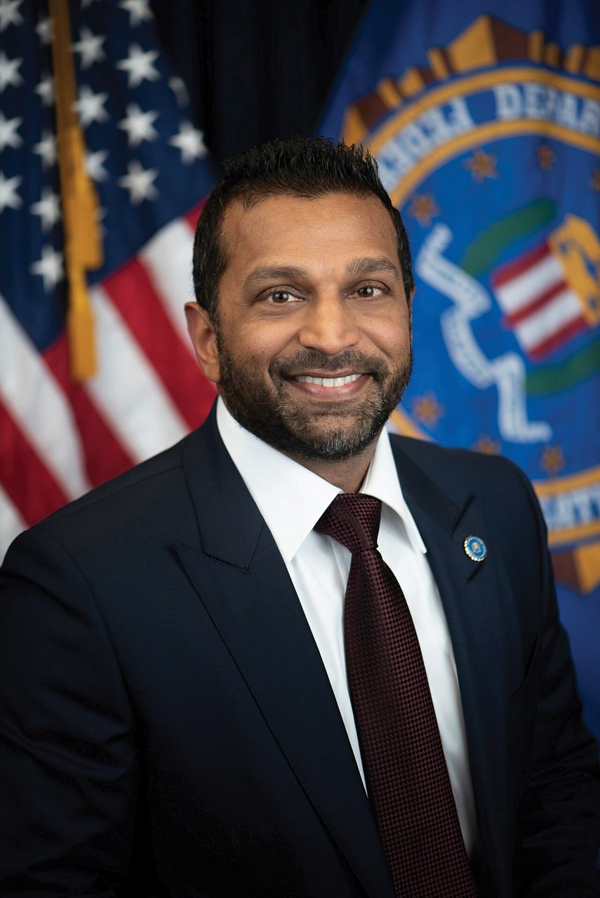 Official portrait of FBI Director Kash Patel, a defendant in the lawsuit, smiling in a dark suit and red tie in front of a U.S. flag and the FBI seal