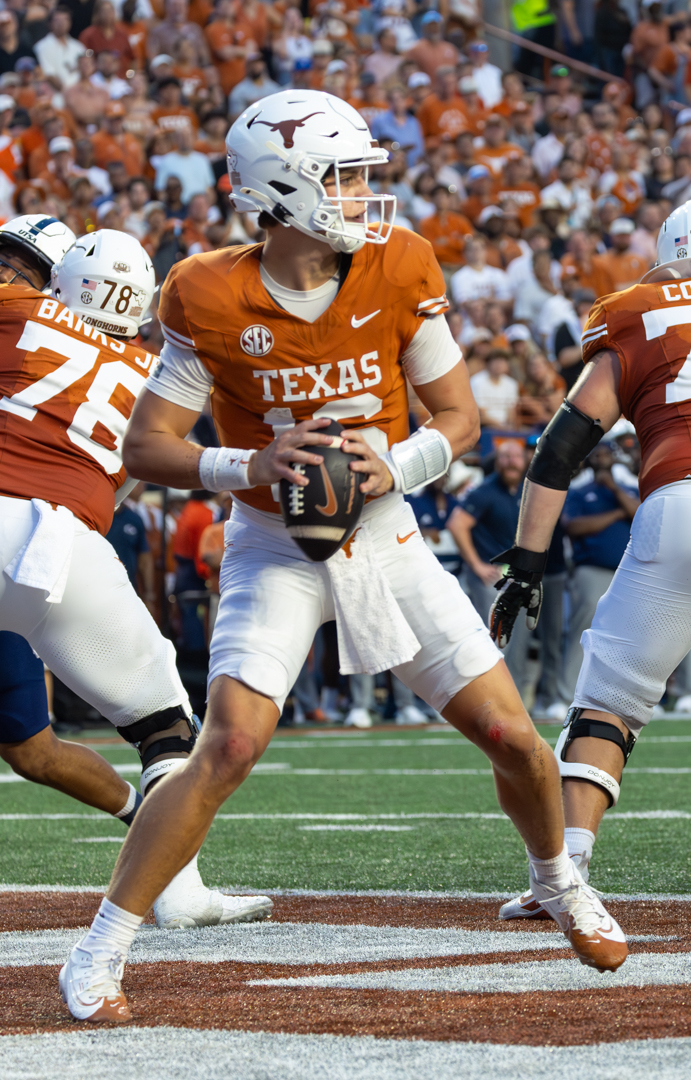 Texas quarterback Arch Manning, in an orange Texas jersey, holds the ball as he drops back to pass during a 2024 home game; no Florida players are pictured
