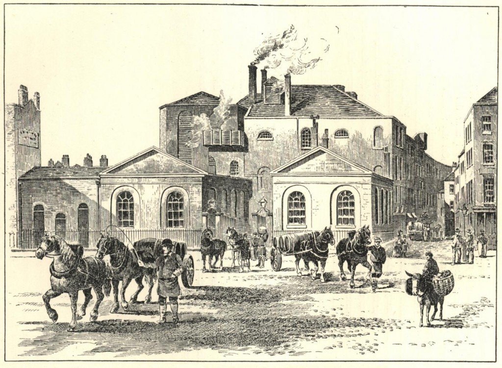 A black-and-white engraving of a large brick brewery with tall chimneys, with horse-drawn carts and workers in the street in front