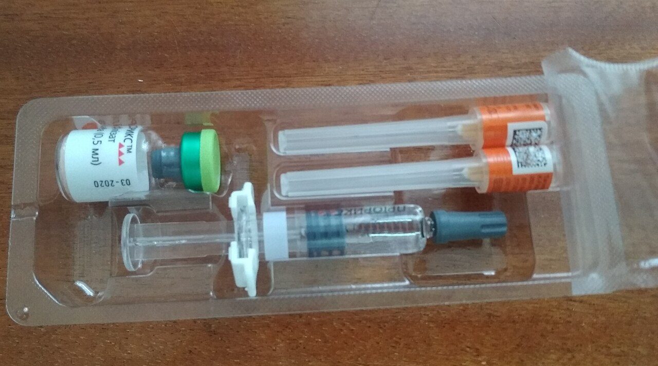 A measles, mumps and rubella vaccine kit in a plastic tray, with a small vial, a prefilled syringe and two capped needles