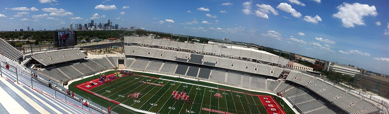 A wide view of the empty seats and green field inside TDECU Stadium in Houston