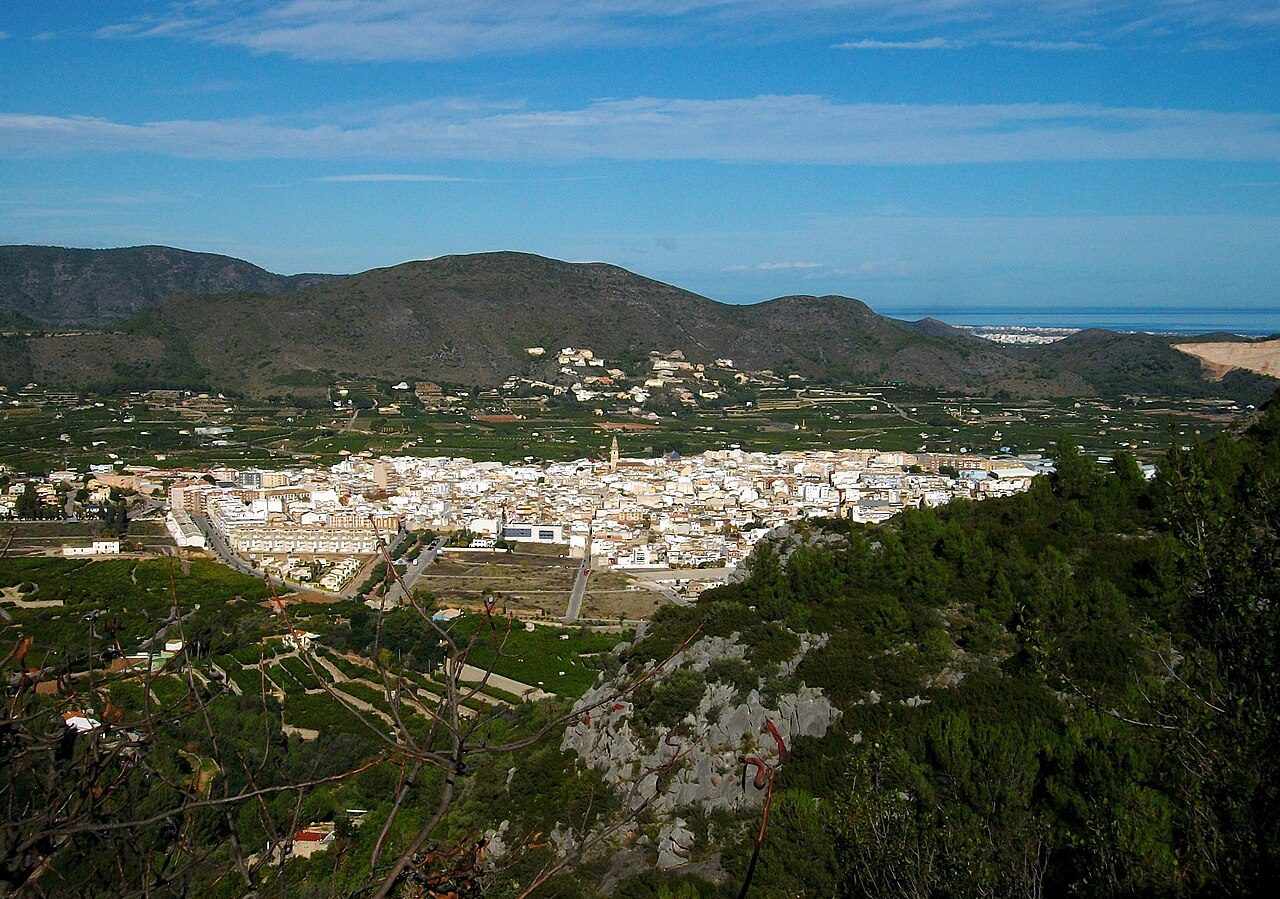 Hillside town of Pego in Alicante province under clear skies, with white buildings and green hills