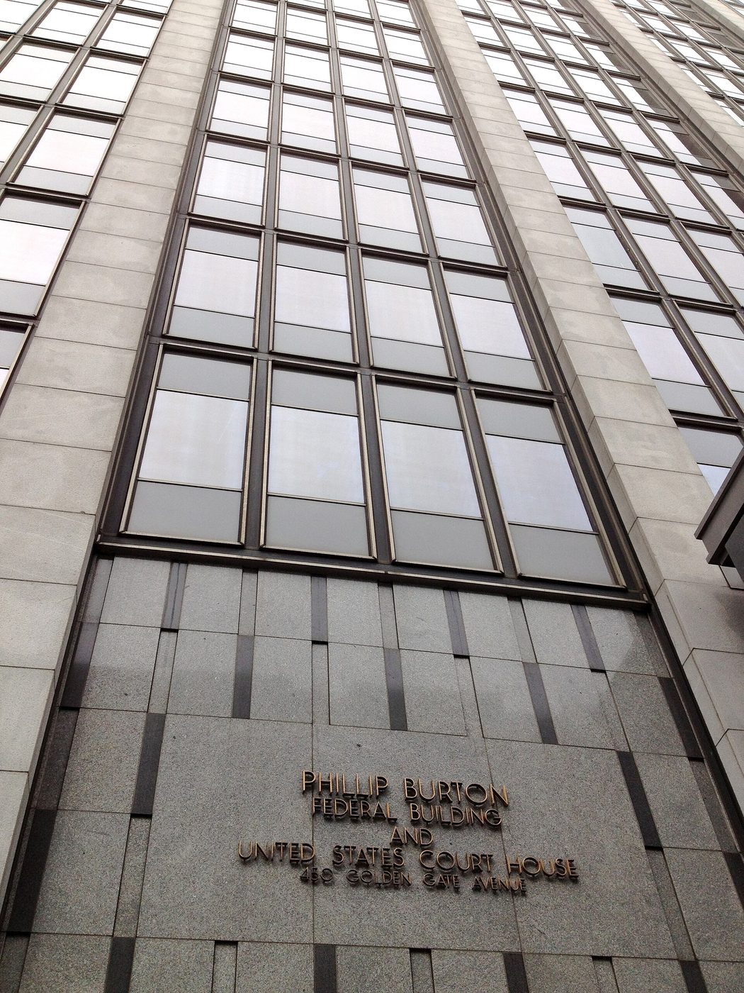 A tall gray federal office building and courthouse in San Francisco on a cloudy day