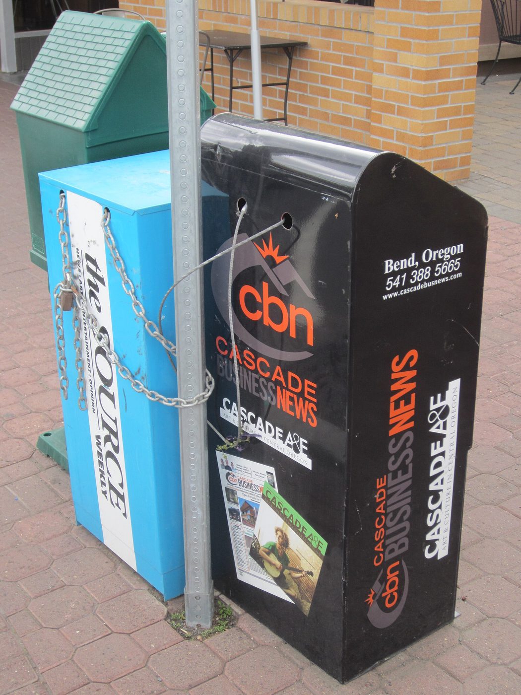 Newspaper boxes on a sidewalk in downtown Bend, Oregon