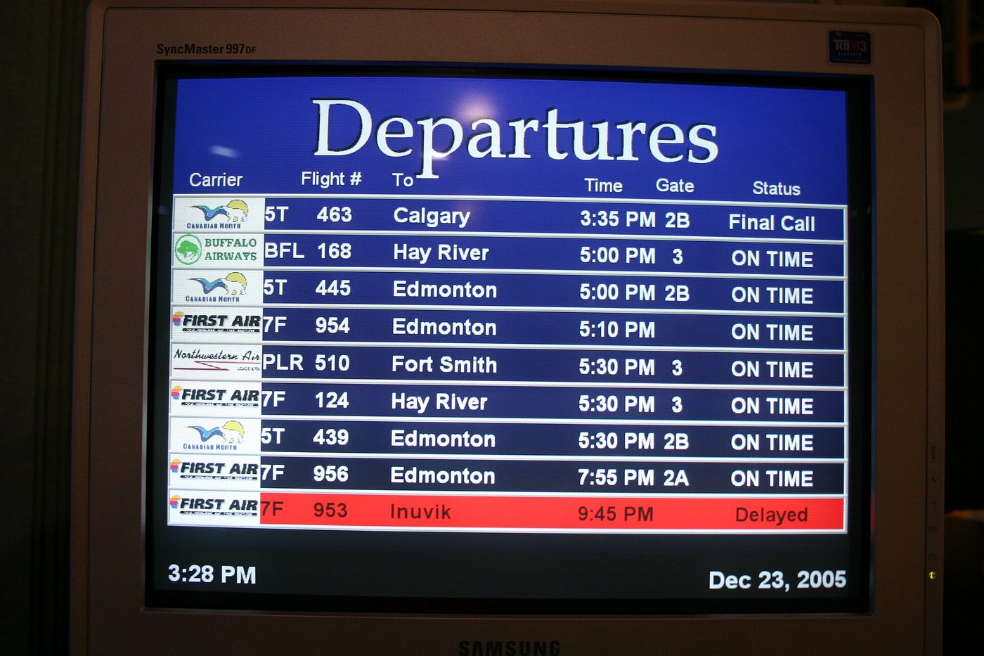 An airport departures screen listing a delayed flight