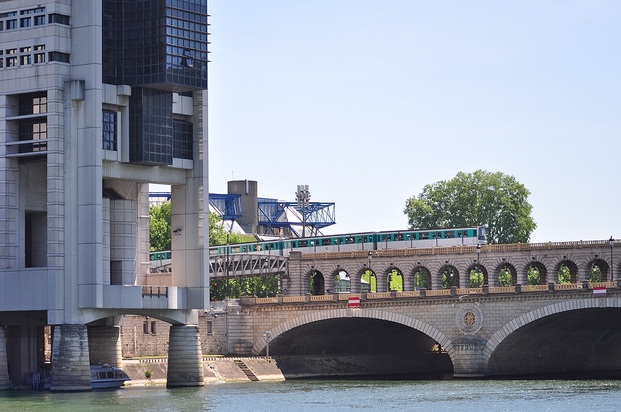 A Paris metro train crosses the Pont de Bercy beside the Colbert building of France's economy and finance ministry