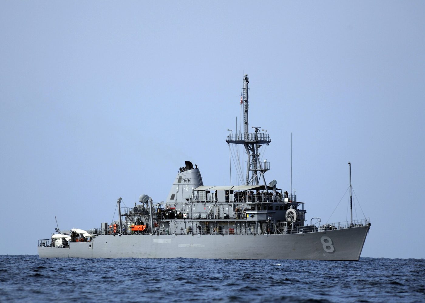 A gray US Navy mine countermeasures ship at sea in the Strait of Hormuz
