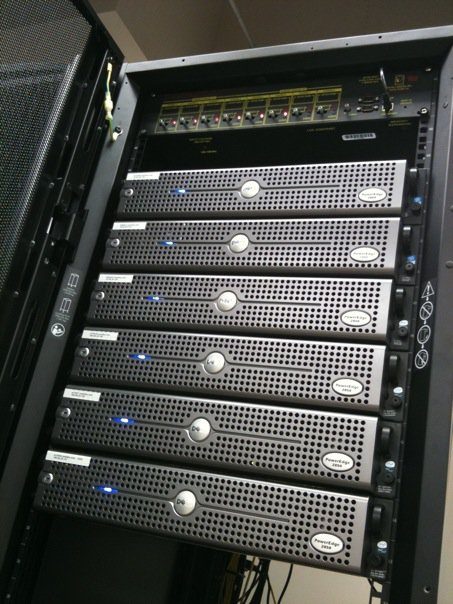 A rack of servers in a data center with blinking lights and cables
