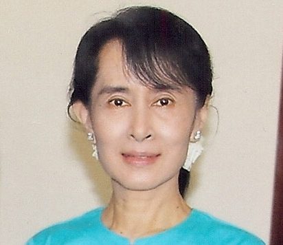 Aung San Suu Kyi with flowers in her hair speaking at her home
