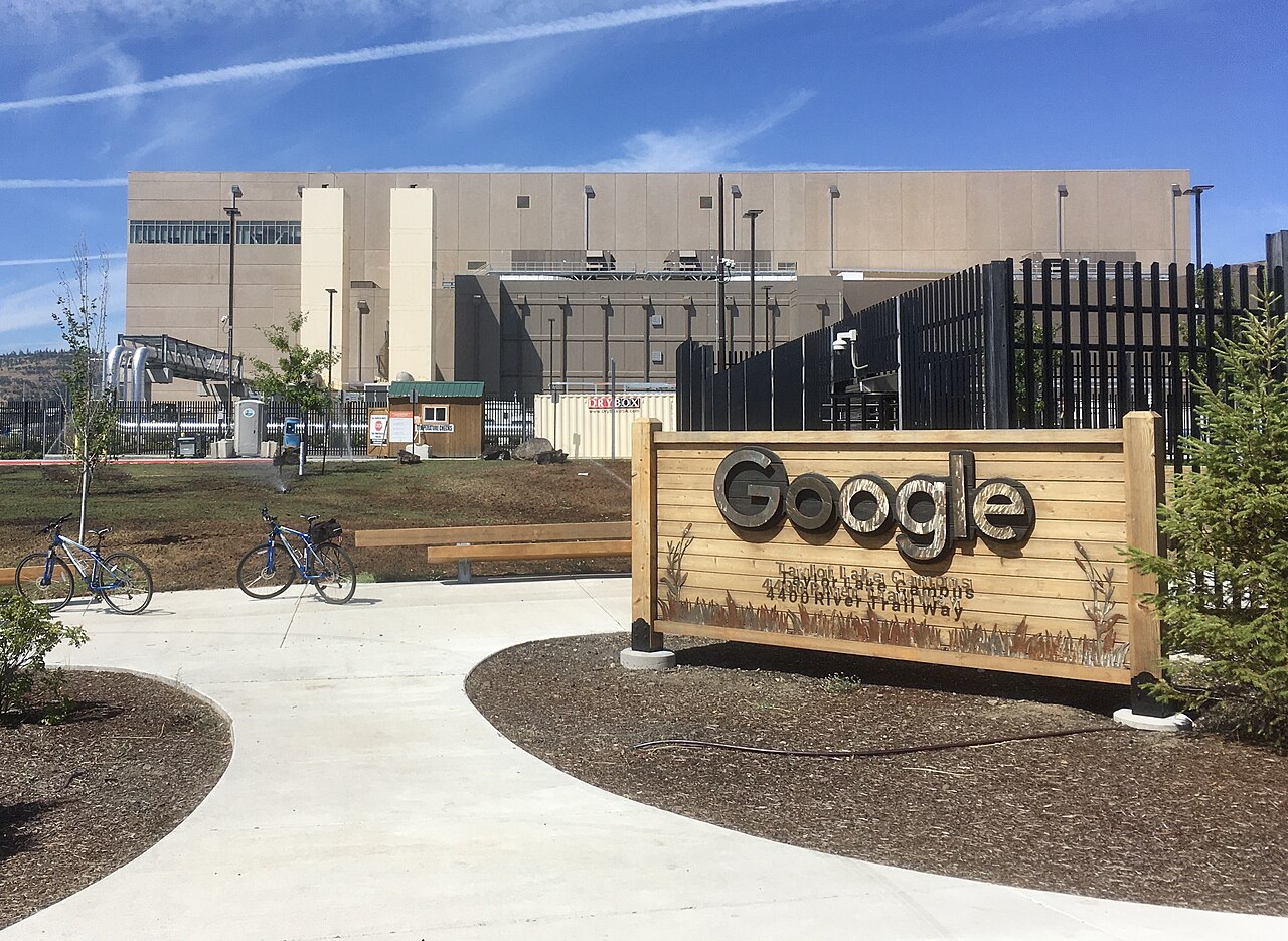 Large Google data center buildings beside a road