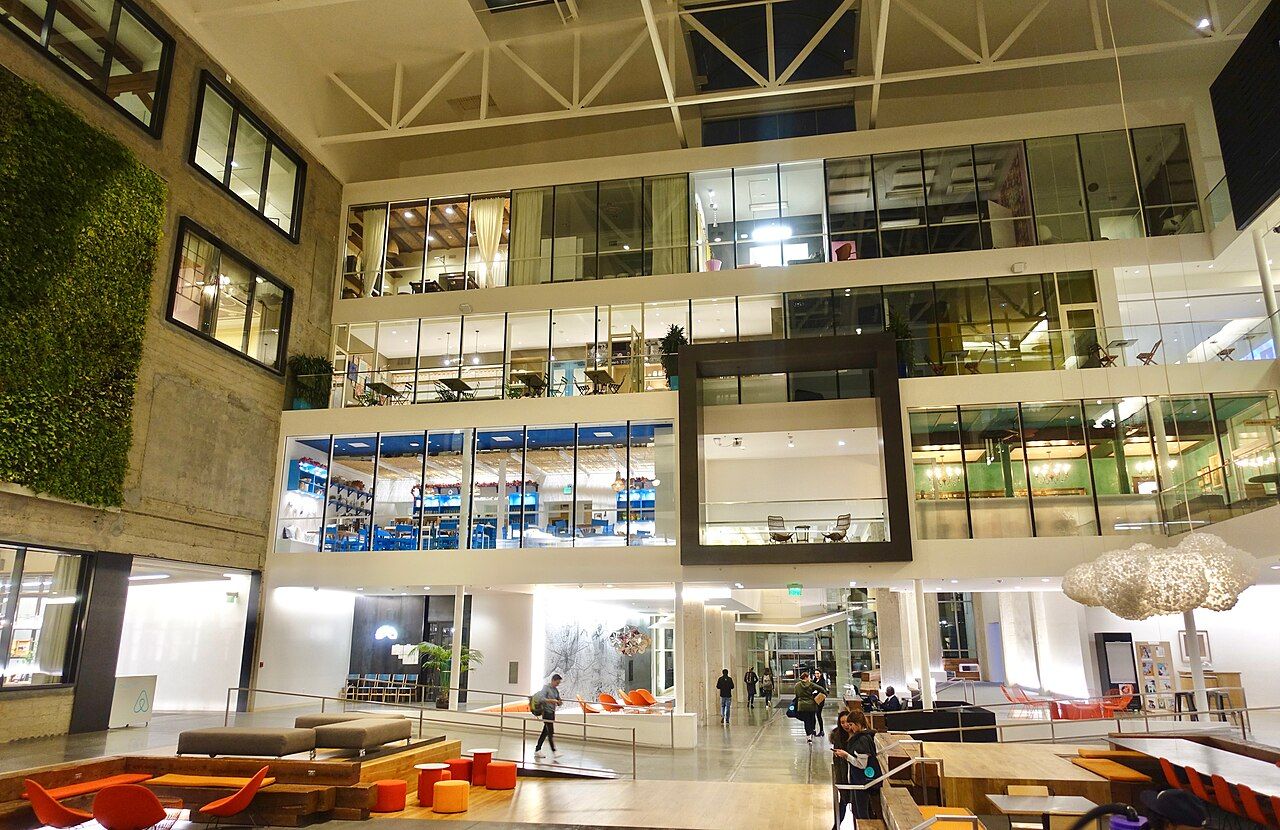 A bright open atrium with several floors of offices and seating areas below