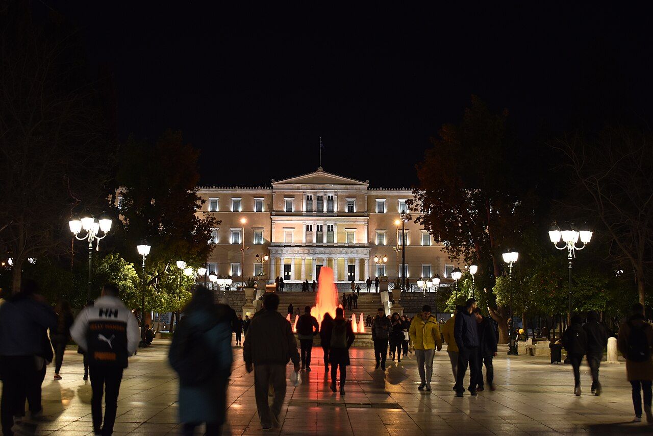 The Greek Parliament building lit up at night above Syntagma Square