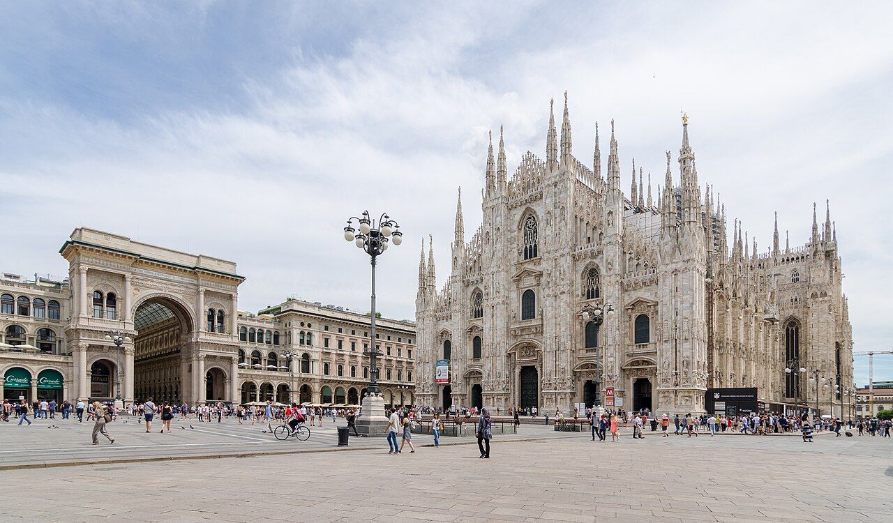 Milan Cathedral's white marble front and the arched entrance to the Galleria Vittorio Emanuele II across a wide square