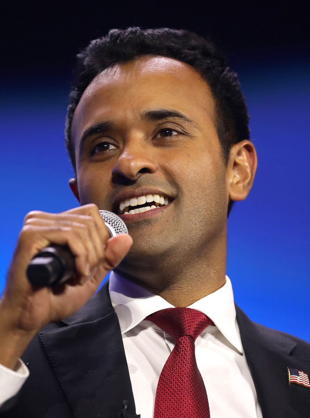 Vivek Ramaswamy speaks into a microphone at an event
