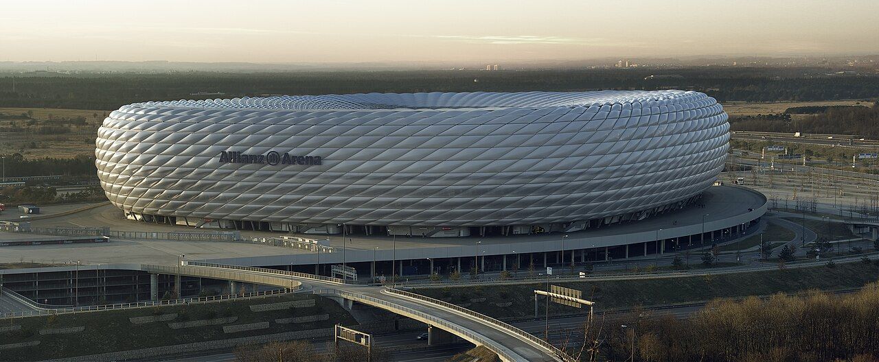 The white, cushion-like outer shell of the Allianz Arena in Munich under a pale sky