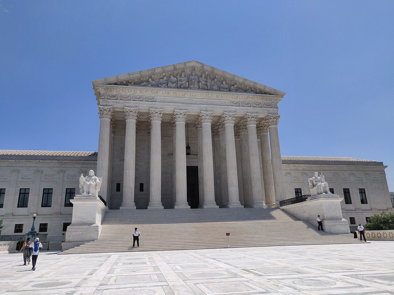 The white marble front and steps of the US Supreme Court building under a blue sky