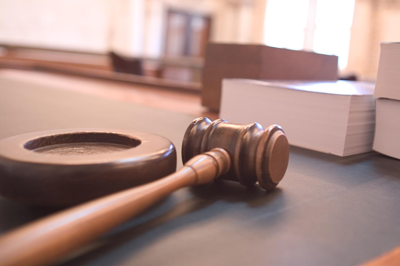 A wooden gavel on a desk in a courtroom