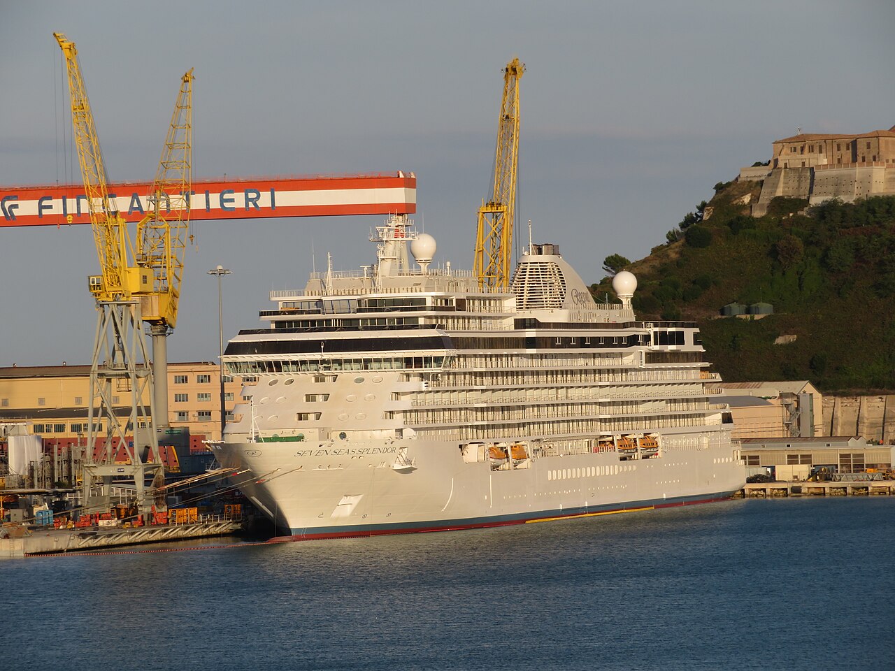The white cruise ship Seven Seas Splendor docked at a port
